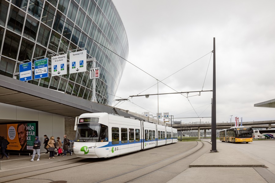 Tram der Glattalbahn und Postauto am Flughafen Zürich